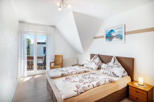 a bedroom with a large bed and a balcony at Ferienwohnungen Meyer in Hochbuch