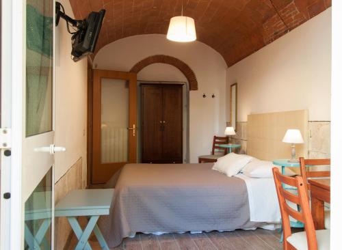 una camera con letto, tavolo e specchio di Bed & Tower a Pisa