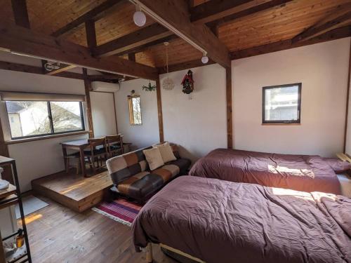 a bedroom with a bed and a couch in a room at guest house antena ゲストハウスアンテナ in Minami Aso