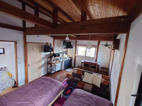 a living room with a bed and a couch at guest house antena ゲストハウスアンテナ in Minami Aso