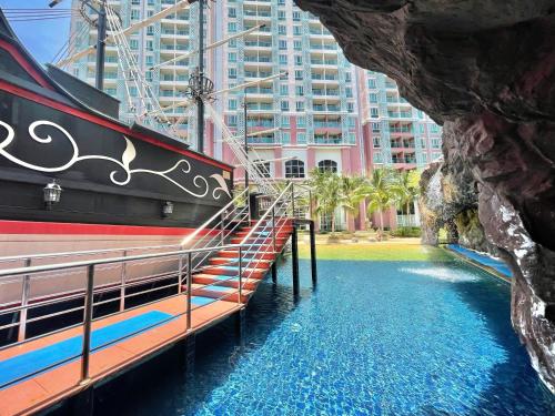 a boat in a body of water with buildings in the background at Accommodation with waterpark in Pattaya South
