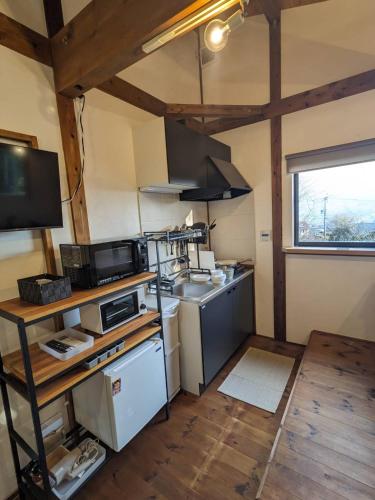 a small kitchen with a stove and a sink at guest house antena ゲストハウスアンテナ in Minami Aso