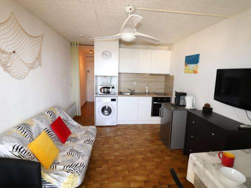 un salon avec un canapé et une cuisine dans l'établissement Studio Cabine 4 pers proche mer et commerces - FR-1-307-208, au Grau-du-Roi
