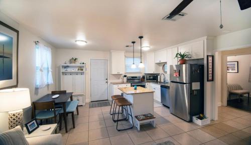 a kitchen with a refrigerator and a table and chairs at 2bd-2ba Adorable Home w Yard in Gentilly in New Orleans