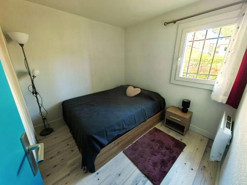 une petite chambre avec un lit et une fenêtre dans l'établissement T2 Climatisé rénové avec Parking et Piscine pour 4 près de la mer - FR-1-607-205, au Cap d'Agde