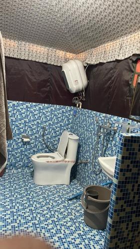 baño con aseo y suelo de baldosa. en Bambooz Bell cottage and camps I Kasauli I Lake View & Trekking, en Kasauli