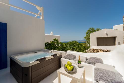 a patio with a hot tub and a table and chairs at SeaView Central Suites in Mýkonos City