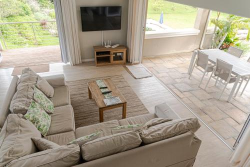 a living room with a couch and a table at The Suites at Waterryk Eco Guest Farm in Stilbaai