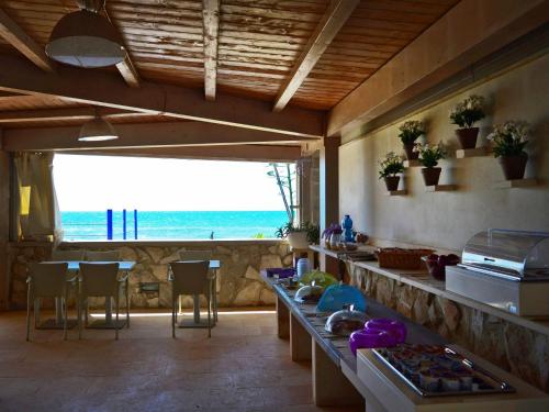 a kitchen with a table and a view of the ocean at Hotel Mar & Sol in Punta Secca