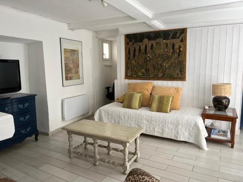 une chambre avec un lit, une table et une télévision dans l'établissement Toulon Mourillon mitre mer, à La Celle-sous-Gouzon