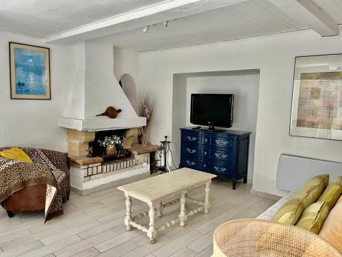 un salon avec une télévision, un canapé et une table dans l'établissement Toulon Mourillon mitre mer, à La Celle-sous-Gouzon