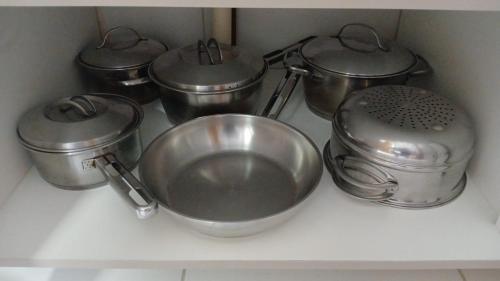 a group of metal pots and pans on a kitchen counter at MALIA MURO ALTO STUDIO 300m DO MAR in Porto De Galinhas