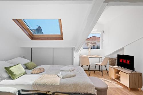 une chambre avec un lit et une télévision dans l'établissement Charme & Soleil au Dernier Étage Libération Nice, à Nice