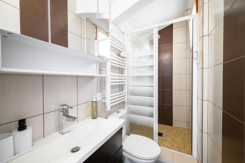 une salle de bain blanche avec des toilettes et un lavabo dans l'établissement Charme & Soleil au Dernier Étage Libération Nice, à Nice