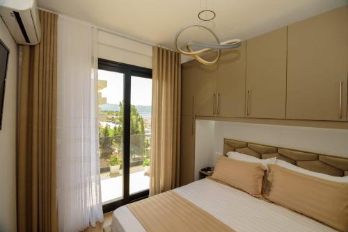 a bedroom with a bed and a large window at Seaside Serenity Apartments - Tirana Resort Radhime in Vlorë