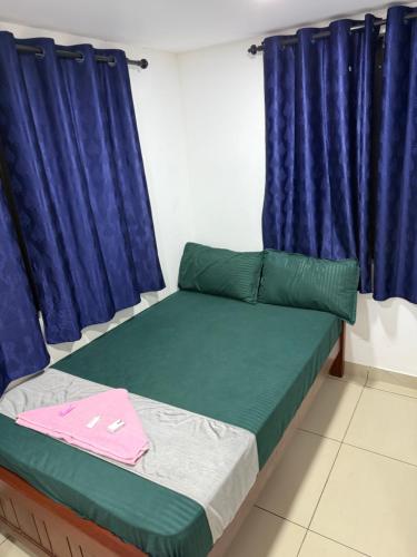 a bedroom with a bed with blue curtains at RJ residency in Kozhikode