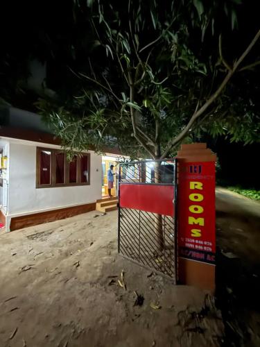 a tree in front of a building with a fence at RJ residency in Kozhikode