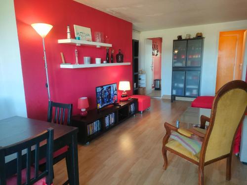 un salon avec des murs rouges et une table et des chaises dans l'établissement Ref 065 Appartement duplex pour sept personnes plage à pied Arzon, à Arzon
