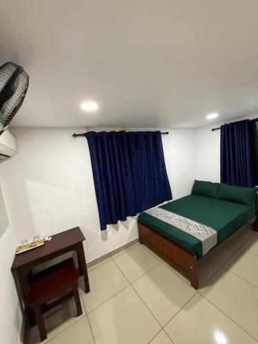 a bedroom with a green bed and a table at RJ residency in Kozhikode