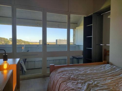 une chambre avec un lit et une grande fenêtre dans l'établissement Ref 065 Appartement duplex pour sept personnes plage à pied Arzon, à Arzon
