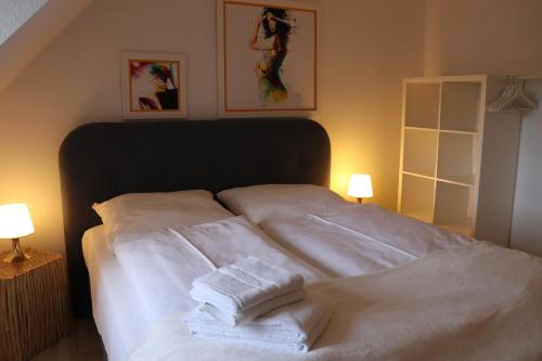 a bed with three towels stacked on top of it at Villa am Schwanenteich in Spremberg