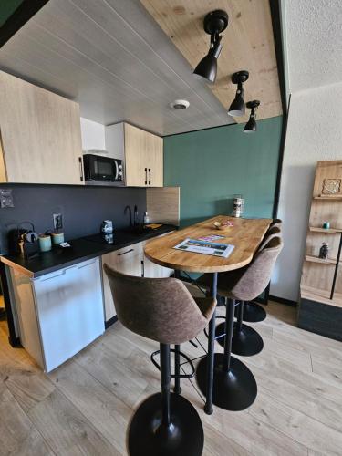 a kitchen with a wooden table and some chairs at The 8 in Lunéville