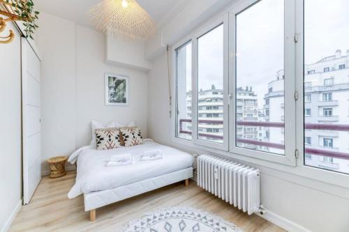une chambre blanche avec un lit et une grande fenêtre dans l'établissement T2 Prestige au cœur de Grenoble, à Grenoble