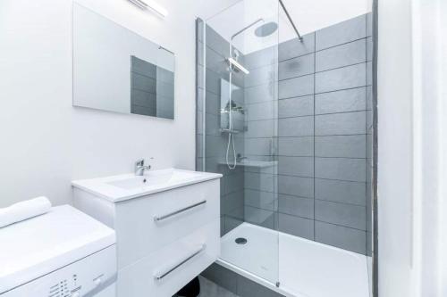 une salle de bain blanche avec un lavabo et une douche dans l'établissement T2 Prestige au cœur de Grenoble, à Grenoble