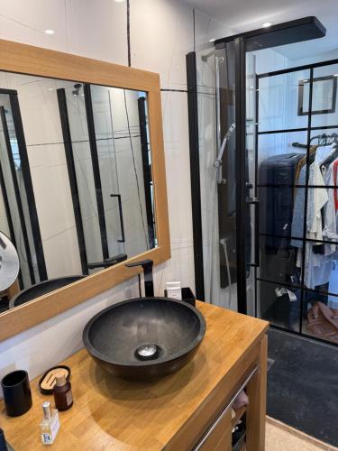 une salle de bain avec un lavabo noir et un miroir dans l'établissement PIEDS DANS l EAU A SANT AMBROGGIO, à Lumio