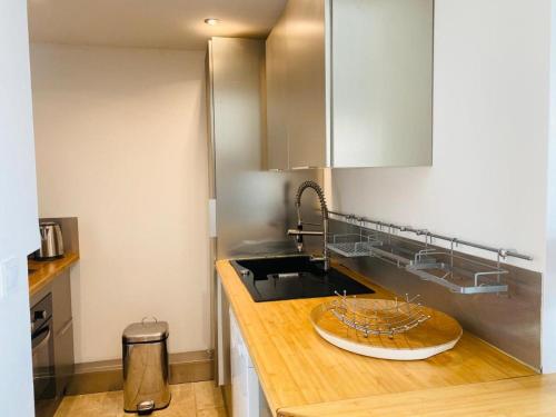 une cuisine avec un évier et un plan de travail en bois dans l'établissement PIEDS DANS l EAU A SANT AMBROGGIO, à Lumio