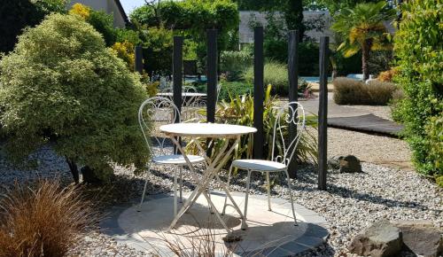 a table and two chairs in a garden at La Tourelle - Bed and Breakfast et gîte in Changé