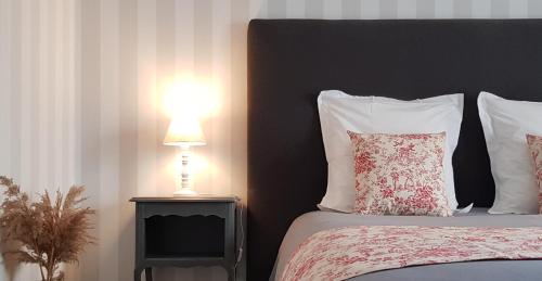 a bedroom with a bed with a lamp on a table at La Tourelle - Bed and Breakfast et gîte in Changé