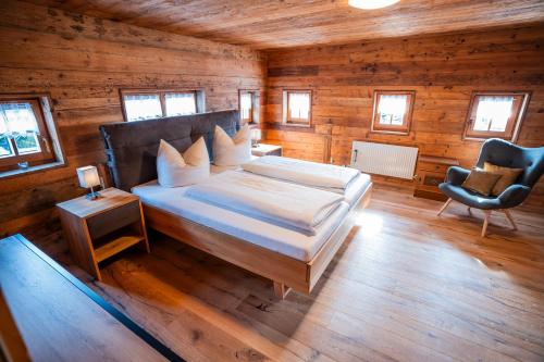 um quarto com uma cama e uma cadeira em um cômodo em Apartment Kracherlemoos em Seefeld in Tirol