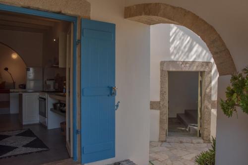 a blue door leading into a kitchen with an archway at Borantza stone house in Aroniadika