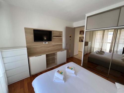 une chambre avec un lit blanc et un grand miroir dans l'établissement B009 Superbe au centre a proximite de la Croisette, à Cannes
