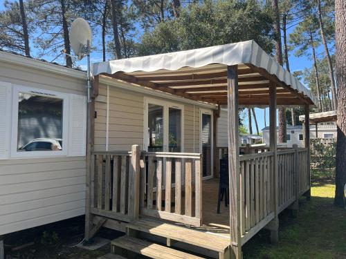 une maison avec un auvent sur son côté dans l'établissement Prix dégressif - Bungalow 4-6 personnes aux Dunes de Contis, à Saint-Julien-en-Born