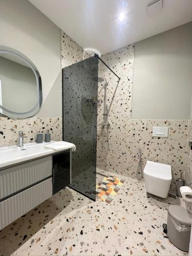 a bathroom with a shower and a sink and a toilet at Guest House Vila Krejs in Durrës