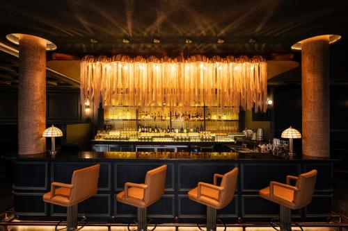 a bar in a restaurant with chairs and a chandelier at Amari Vientiane in Vientiane