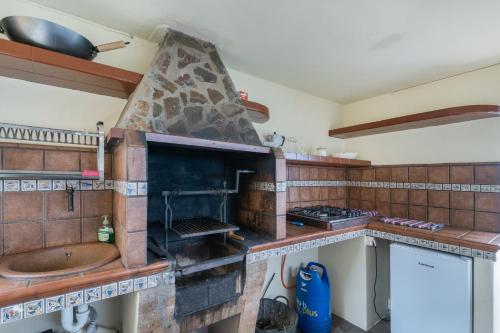 cocina con horno de piedra y fregadero en Vv Terrazita, en Tijarafe