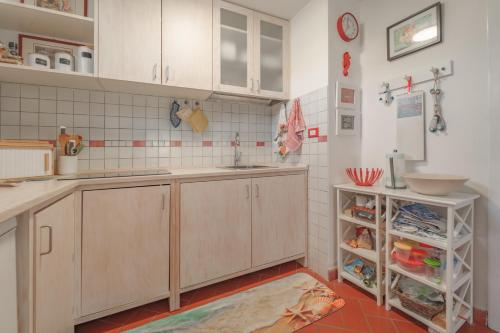 a kitchen with wooden cabinets and a sink at Casa Celeste - Goelba in Pomonte