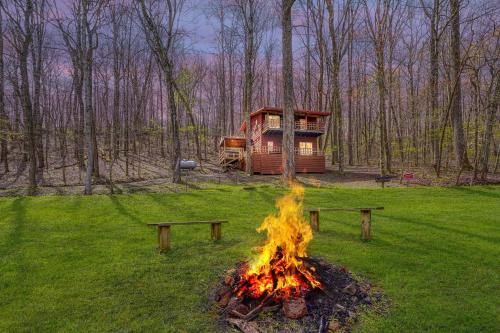 a campfire in front of a cabin in the woods at Wyandot Woods - Cedar House in Laurelville