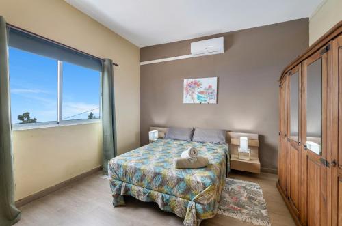 Un dormitorio con una cama y una ventana grande. en Vv Terrazita, en Tijarafe