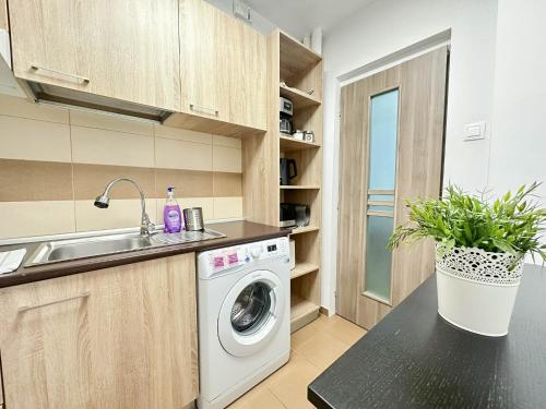 a kitchen with a washing machine and a sink at Sunrise Apartments City Center in Bucharest
