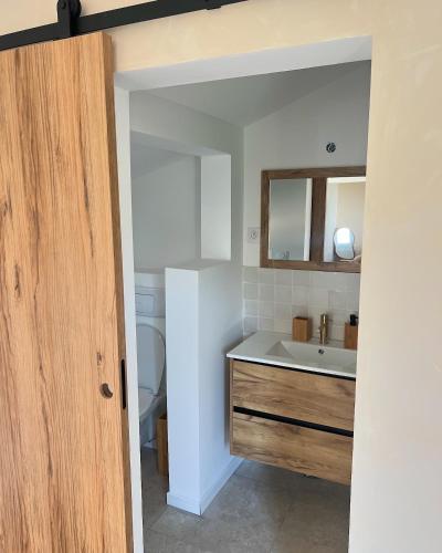 une salle de bain avec un lavabo et un miroir dans l'établissement Maison Poulette, à Tosse
