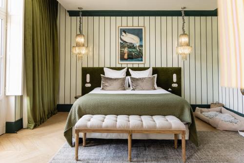 a bedroom with a large bed and a bench at Château Léognan, Domaine viticole - proche Bordeaux in Léognan