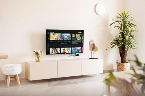 a living room with a tv on a white cabinet at CAPTAIN'S RESIDENCE in Ksamil