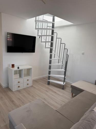 a living room with a spiral staircase in the wall at Ranczo Ryki in Nowy Dwór Gdański