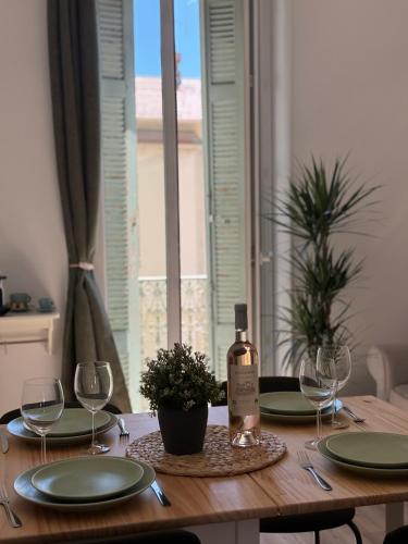 - une table en bois avec une bouteille de vin et des verres dans l'établissement La Suquette cosy 3 pieces, à Cannes