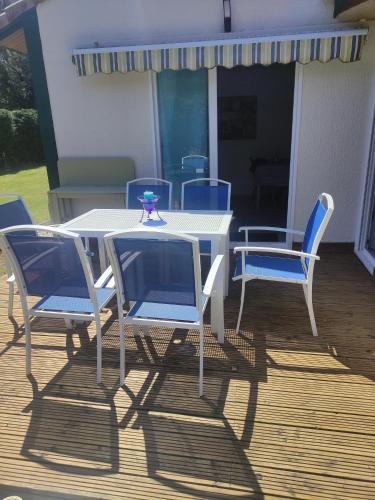une table et des chaises blanches sur une terrasse dans l'établissement Villa jendy, à Soustons