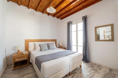 a bedroom with a large bed and a window at SeaView Central Suites in Mýkonos City